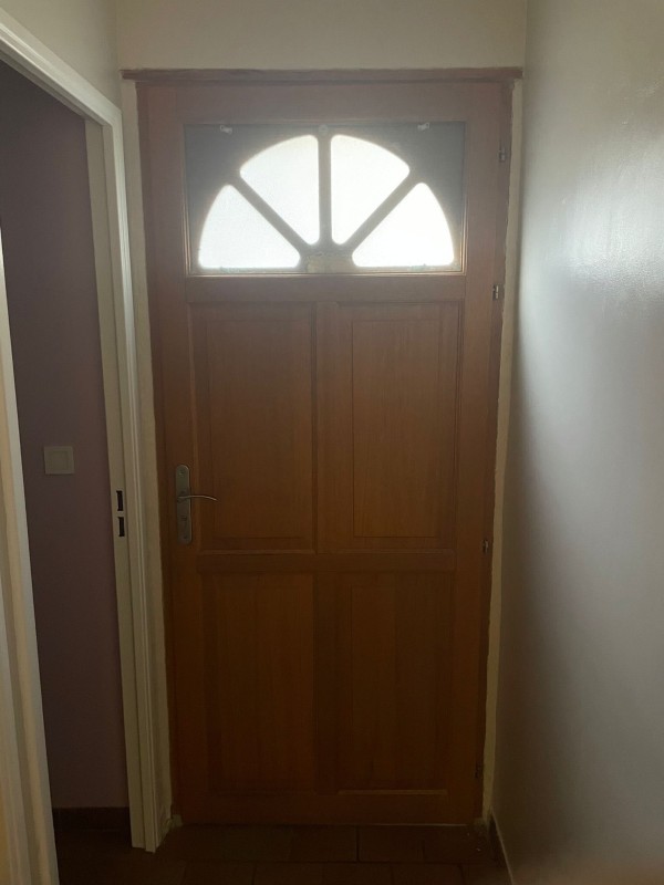 Ancienne porte en bois avant remplacement par une nouvelle porte en acier isolée sur Les Mees