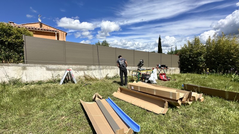 Mise en place clôture brise vu en aluminium sur mur en pente.