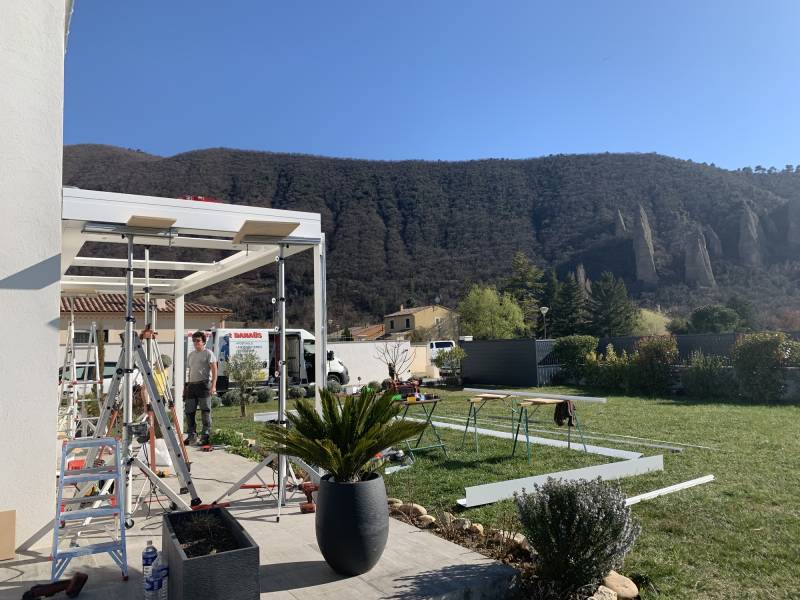Photo pendant la pose d'une pergola ARTHOMEALU avec une superbe vue sur les pénitents des MEES
