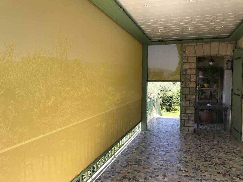 Vue intérieure sous une pergola bioclimatique avec store screen baissé sur Volonne