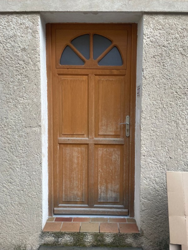 Vieille porte d'entrée en bois avant son remplacement par un modèle isolé sur Les Mees
